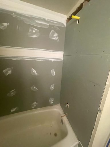 Bathroom renovation in progress, with exposed drywall and a bathtub.